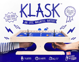 Klask board game by Buffalo Games, featuring a blue playing field and wooden frame. Two players are engaged, each holding a control piece, aiming to score by getting a small ball into the opponent's goal. The packaging emphasizes its popularity with '500,000 games sold!' and highlights the game as a 'multi-award winning' experience designed in Denmark.