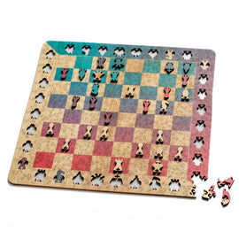A beautifully crafted wooden chess puzzle featuring a vibrant sunset color scheme. The jigsaw shows intricately designed chess pieces set against a stylized board with swirling patterns, showcasing a mix of reds, blues, and yellows.
