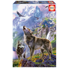 Educa jigsaw puzzle titled 'Wolves in the Rocks', featuring a stunning landscape with two wolves in a mountainous setting. The box includes 500 high-quality pieces, showcasing rich colors and intricate details, perfect for nature lovers and puzzle enthusiasts.