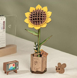 The Sunflower Model by Robotime is a vibrant DIY kit featuring a colorful sunflower with a wooden base. The yellow flower has detailed petals and a textured center, while the green stem and leaves provide a realistic look. Additionally, the kit includes a small cardboard TV and a cute bee figure, adding to the charming display. Perfect for craft enthusiasts looking for a fun project.