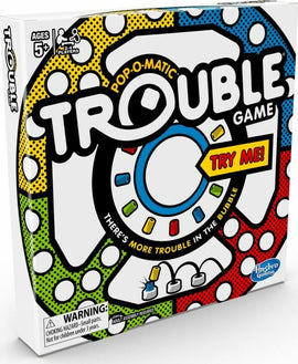 The Trouble game by Hasbro features a colorful, pop-o-matic design on the box with the game title prominently displayed. It indicates playing age 5+, suitable for 2-4 players. The box has a 'Try Me!' tag and a warning label about small parts. The vibrant colors and iconic bubble feature promise fun and excitement in gameplay.