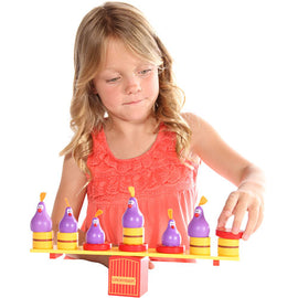 A young girl playing with the Chickyboom game by Blue Orange U.S.A. The game features colorful chickens and a balancing platform, encouraging fun interaction and skill development.