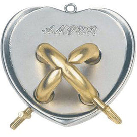 The Cast Amour mechanical puzzle by Hanayama features a heart-shaped design with intricate golden and silver interlocking pieces. The word 'AMOUR' is elegantly engraved on the surface, highlighting its romantic theme. Two key components are visible on the sides, indicating how the pieces interact in this challenging puzzle.