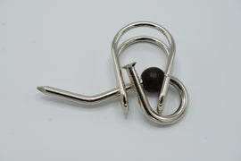 A U-Nagel mechanical puzzle by Jean-Claude Constantin, featuring intricate metal loops and a wooden bead. The design showcases a unique twisting mechanism aimed at providing mental stimulation and challenging users to find solutions. Ideal for puzzle enthusiasts and those looking for a brain teaser.
