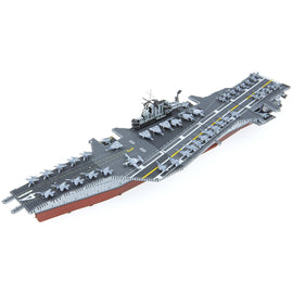 A detailed DIY metal model kit of the USS Midway aircraft carrier by Fascinations, featuring intricately designed metal parts, a realistic flight deck, and miniature fighter jets positioned on the deck.