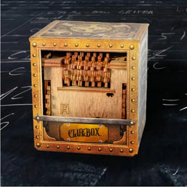 The Cluebox: Schrodinger's Cat by IDventure is a beautifully crafted mechanical puzzle. It features a cube-shaped design with intricate wooden mechanisms visible through a clear front panel. The puzzle is adorned with vintage steampunk elements, including brass accents and bolts, giving it an antique feel. The box is designed as a mind-bending challenge that requires reasoning and problem-solving to unlock it.