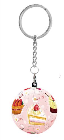 A Strawberry Party Puzzle Keychain featuring a colorful jigsaw puzzle design, with images of strawberries, cake, and sweets on a pink background. Attached to a silver chain, this keychain is both a decorative item and a fun puzzle to assemble.