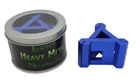 Heavy Metal: Triad mechanical puzzle by Eureka Puzzles. The product includes a blue triangular puzzle piece beside a round tin container featuring the product name and logo on a black background.