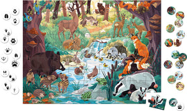 The Footprint Seek & Find Puzzle by Janod features a vibrant and colorful jigsaw scene depicting a lush forest with various animals including deer, foxes, and a boar near a stream, surrounded by trees and foliage. Accompanying the puzzle are circular tokens showcasing animal tracks, enhancing the interactive search experience for kids.