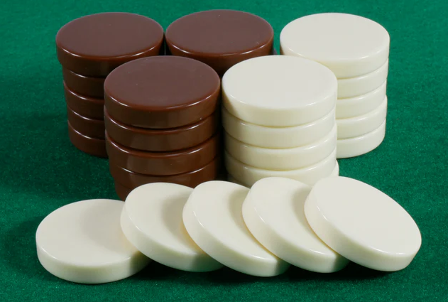 A set of 1.25-inch checkers featuring a combination of brown and ivory pieces. The brown checkers are stacked in a neat formation alongside ivory checkers, creating a striking contrast. The background is a vibrant green felt, typical for board games, enhancing the focus on the game pieces.