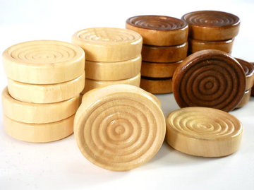 A collection of wooden checkers pieces, featuring a mix of light and dark shades. The pieces are smooth and round, showcasing a spiral design on top. Perfect for playing traditional checkers.