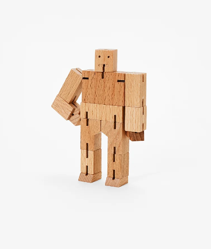 Cubebot Micro - Guthrie by Harmony Ball, a mechanical puzzle made of wooden blocks. The figure is posed in a standing position, showcasing movable joints and a simplistic design, perfect for both play and display.