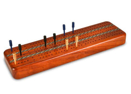 A beautifully crafted Cribbage board made of Padauk wood, featuring deep grooves and holes for pegs. The board is polished and highlights intricate details, providing an elegant look for gaming enthusiasts. Six pegs in varying colors are displayed atop the board, ready for gameplay.