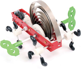 The Awika! Wind Up Gear Bot is a vibrant mechanical toy featuring a red base adorned with colorful gears and wind-up keys, showcasing intricate moving parts that operate when wound up.
