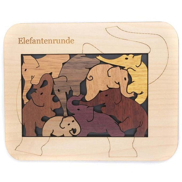 Elefanten - Micro by Jean-Claude Constantin is a wooden mechanical puzzle featuring intricately designed elephant pieces in various colors. The pieces fit within a matching outline on a smooth wooden base, creating a fun and engaging challenge for puzzle enthusiasts of all ages.