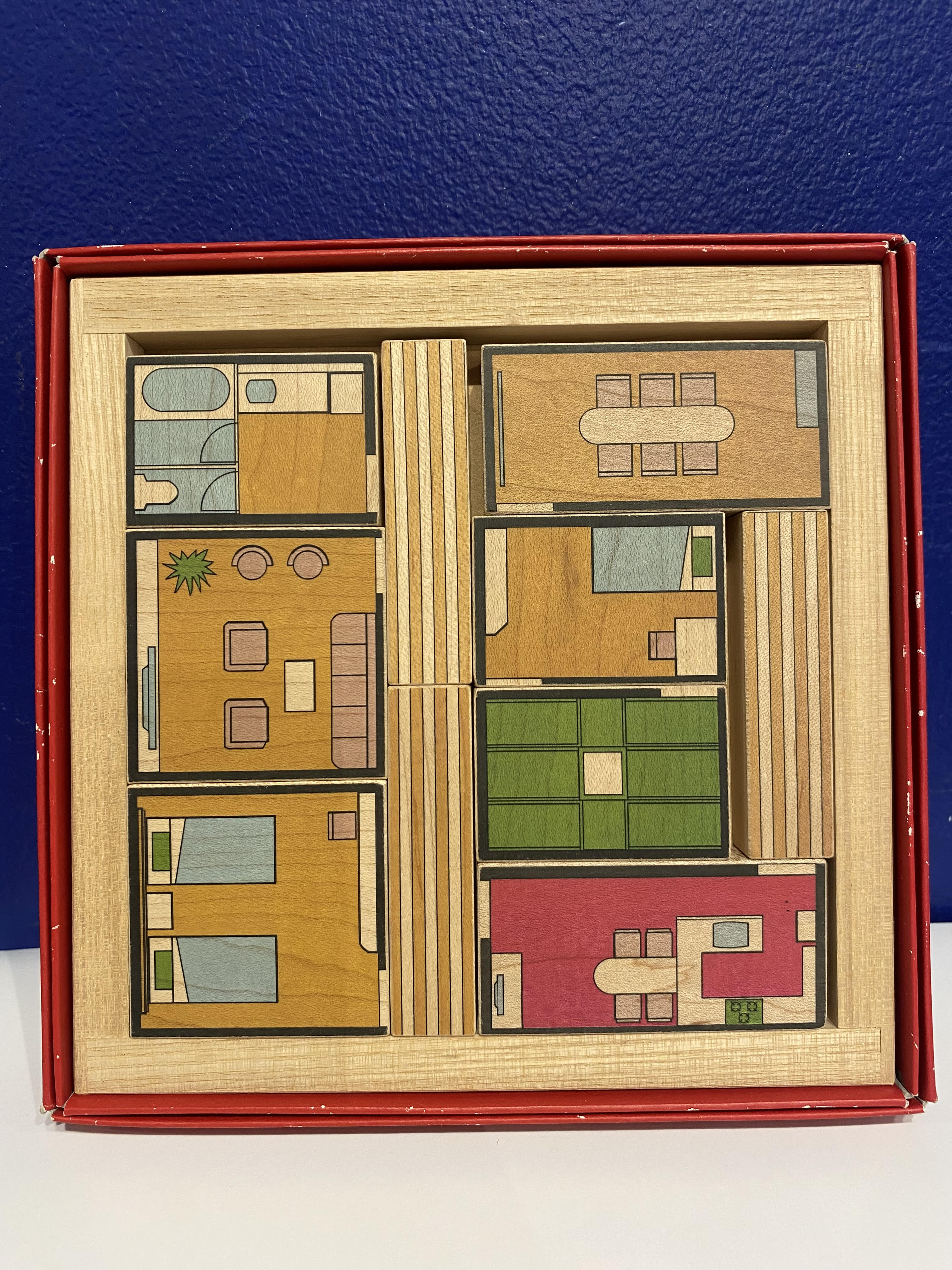 Madori Room Floor Plan Puzzle by Torito, featuring intricately designed wooden pieces that depict various rooms in a house layout. Each piece is uniquely shaped and color-coded, inviting creative play and problem-solving as you assemble the space.