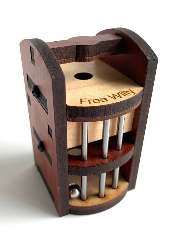 The Free Willy mechanical puzzle by Jean-Claude Constantin features a compact wooden design with two levels, segmented by metallic rods. The top section has a circular hole, and the wooden base includes an engraved label. The puzzle challenges users to navigate a ball through the obstacles for a fun, engaging experience.