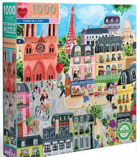 The 'Paris in a Day' jigsaw puzzle by Eeboo features a vibrant, illustrated scene of Parisian life. This 1000-piece rectangular puzzle showcases iconic Parisian landmarks, including the Eiffel Tower and charming streets bustling with pedestrians and colorful storefronts, such as a boulangerie. The artistic design captures the essence of Paris, inviting puzzlers to immerse themselves in the city's culture and beauty while assembling the pieces.