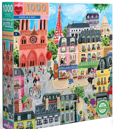 The 'Paris in a Day' jigsaw puzzle by Eeboo features a vibrant, illustrated scene of Parisian life. This 1000-piece rectangular puzzle showcases iconic Parisian landmarks, including the Eiffel Tower and charming streets bustling with pedestrians and colorful storefronts, such as a boulangerie. The artistic design captures the essence of Paris, inviting puzzlers to immerse themselves in the city's culture and beauty while assembling the pieces.