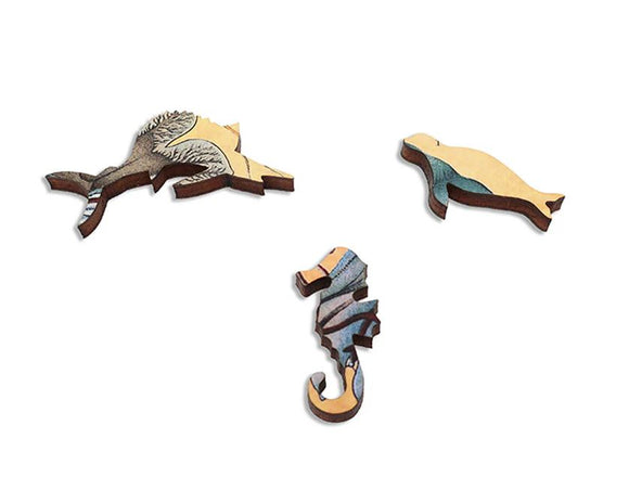Pieces of the Jellyfish jigsaw puzzle by Artifact Wooden Puzzles, featuring intricate designs of marine life, including a seahorse and a playful seal, crafted from high-quality wood.