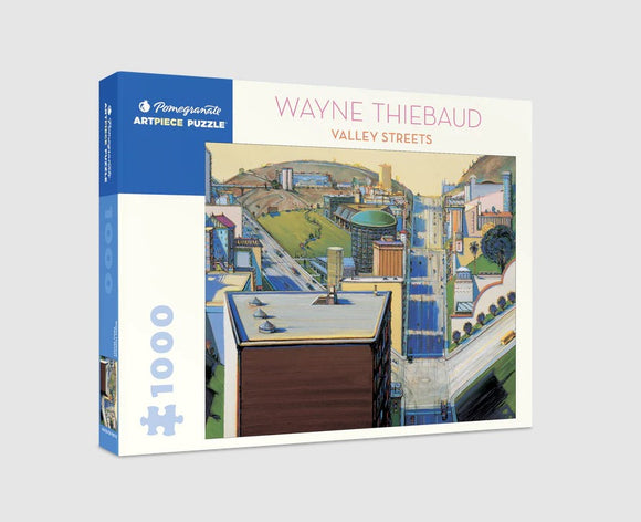 A 1000-piece jigsaw puzzle featuring Wayne Thiebaud's artwork titled 'Valley Streets.' The puzzle box is prominently displayed, showcasing the vibrant colors and urban landscape seen in Thiebaud's painting, complete with buildings and winding streets.