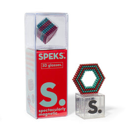 A clear packaging of SPEKS Stripes 3D Glasses featuring a colorful magnetic construct shaped like a hexagon beside the box. The box displays vibrant red and teal design with text highlighting the product as 'spectacularly magnetic' and suitable for adults. A smaller cube-shaped magnetic construct is partially visible in the box.