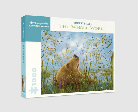 Jigsaw puzzle box featuring Robert Bissell's artwork 'The Whole World.' The design showcases a bear surrounded by colorful flowers and wildlife under a blue sky, enticing nature lovers and puzzle enthusiasts.