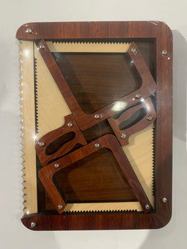 Sagerei by Jean-Claude Constantin is a captivating mechanical puzzle featuring intricately designed wooden pieces resembling tools like saws and squares, all presented in a clear display case. The puzzle invites users to engage their problem-solving skills as they manipulate the various components to achieve a solution.