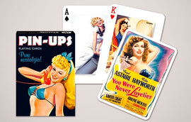 A deck of Pin Ups playing cards by Piatnick. The box features a vintage pin-up girl in a bikini, with the words 'Pure nostalgia' prominently displayed. Two playing cards are visible, one showing the Ace of Spades and the other showing the King of Hearts, both featuring glamorous pin-up art.