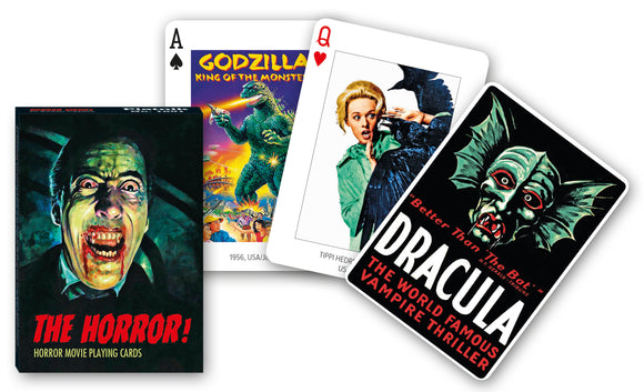 A set of horror movie playing cards titled 'The Horror!' created by Piatnick. The pack features iconic characters such as Dracula and Godzilla, along with classic horror imagery. The packaging showcases a chilling illustration of a vampire with blood-stained teeth and vibrant graphics reflecting classic horror cinema.
