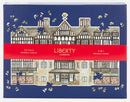 Liberty London Tudor Building jigsaw puzzle featuring a beautifully illustrated design of the iconic Tudor architecture, showcasing intricate details and colors, suitable for puzzle enthusiasts. The packaging displays a 750-piece double-sided challenging puzzle with shaped pieces.