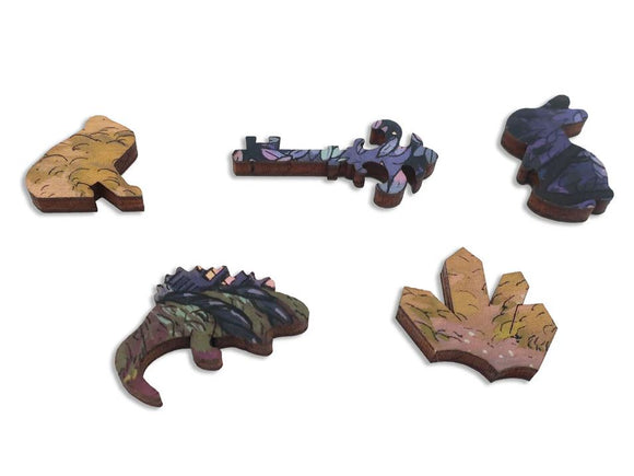 Five unique jigsaw puzzle pieces from the Mosslands collection by Artifact Wooden Puzzles. Each piece features intricate designs with earthy tones and vibrant patterns inspired by nature, showcasing a variety of shapes including animals and natural elements.