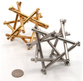The Nova Plexus Limited Edition Pair, featuring a mechanical puzzle made of brass and steel. The brass piece shines brightly with golden hues, while the steel piece gleams with a silver finish. Both pieces are intricately designed, showcasing intertwining shapes, set against a plain background with a quarter for size reference.