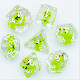 A colorful Frog RPG Dice Set by Foam Brain featuring seven transparent dice filled with vibrant green frog designs. The set includes a d20, d12, d10, d8, d6, d4, and a d100, all with clear faces and white numerals, ideal for role-playing games.