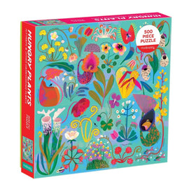 A colorful packaging of the Hungry Plants jigsaw puzzle by Galison. The box showcases a vibrant illustration of various plants and flowers, featuring 500 pieces. The design is playful and eye-catching, perfect for puzzle enthusiasts and nature lovers alike.