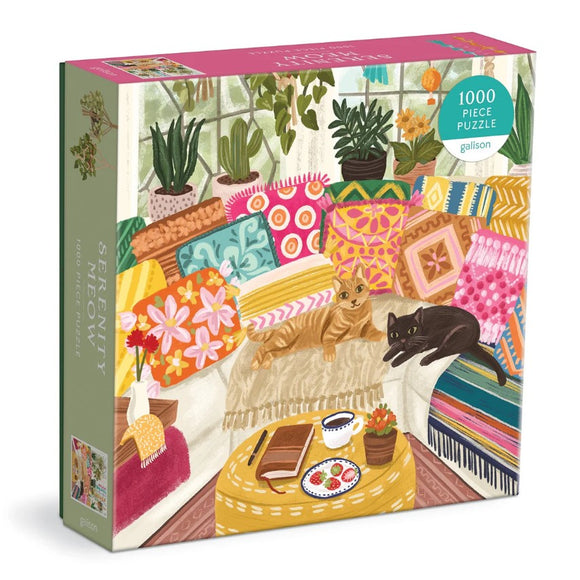 Serenity Meow jigsaw puzzle by Galison featuring a cozy indoor scene with two cats lounging on a colorful assortment of cushions. The background includes plants and a coffee table with snacks and a book, creating a serene and inviting atmosphere. This 1000-piece puzzle combines vibrant colors and intricate designs for a delightful puzzle experience.