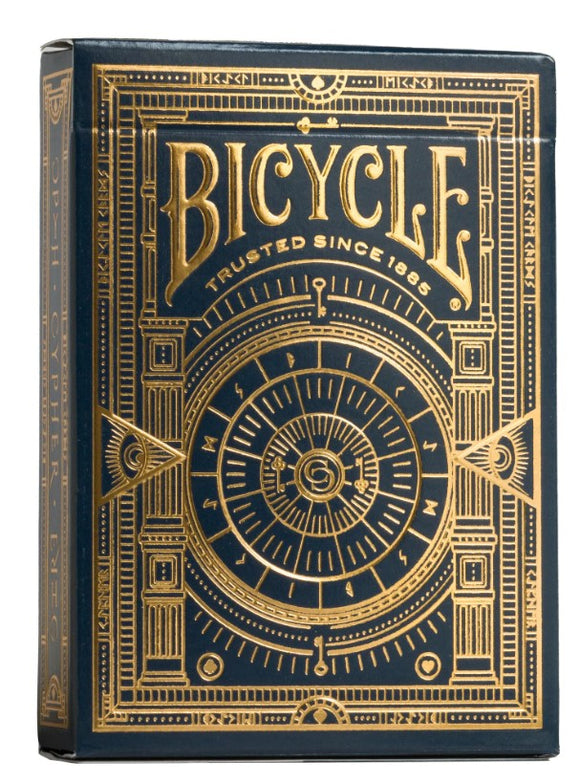 Bicycle Cypher Cards game packaging featuring an elegant design with gold and navy blue tones. The box showcases intricate patterns and the iconic Bicycle logo, conveying a sense of quality and tradition.
