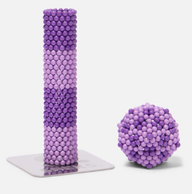 The Speks Elements: Cumulus includes a tall, cylindrical structure made of interlocking purple and lavender magnetic spheres, alongside a spherical cluster of the same colored spheres. Both pieces are designed for creative building and fidgeting.