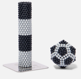 The Speks Elements: Lunar set features a tall cylindrical shape and a compact spherical design made from interlocking magnetic balls in black and white. The cylindrical piece showcases alternating black and white stripes, while the spherical piece resembles a soccer ball pattern. These pieces can be arranged in various shapes, promoting creativity and stress relief.