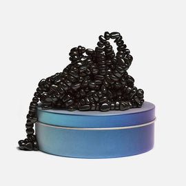 The Crags: Serenity by SPEKS features a tactile, intricate arrangement of black beads spilling from a sleek, gradient blue tin. This sensory toy offers both visual appeal and a satisfying tactile experience, perfect for stress relief and mindfulness.