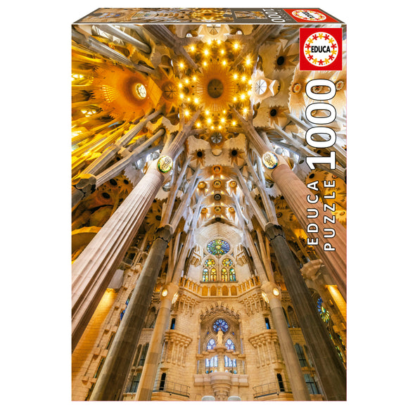 Box of the Sagrada Familia Interior jigsaw puzzle by Educa. The image showcases the stunning interior architecture of the Sagrada Familia with intricate columns and colorful stained glass windows. This 1000-piece jigsaw puzzle offers an immersive experience in recreating the iconic basilica's luminous design, perfect for puzzle enthusiasts and art lovers alike.