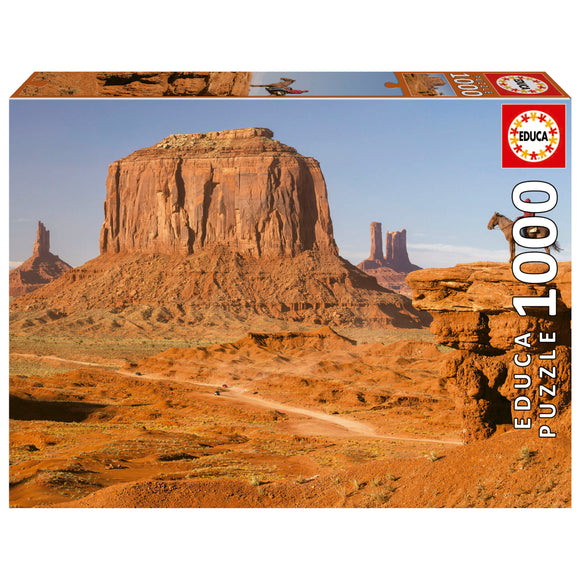 A jigsaw puzzle box featuring the stunning landscape of Monument Valley, showcasing iconic red rock formations and a serene desert scene. The packaging displays the product title 'MONUMENT VALLEY' and consists of 1000 pieces, perfect for puzzle enthusiasts and nature lovers alike.