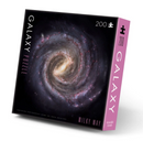 Galaxy Puzzle Milky Way by Crocodile Creek. A 200-piece jigsaw puzzle featuring a stunning image of the Milky Way galaxy, showcasing vibrant colors and intricate details. The puzzle box has a sleek design with the title prominently displayed, highlighting its beautiful cosmic theme.