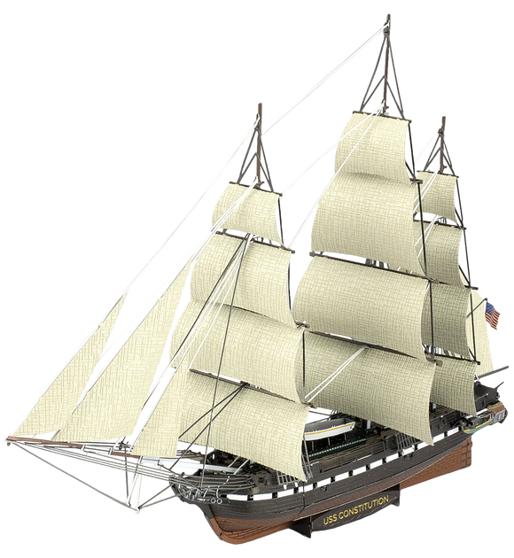 A detailed model kit of the USS Constitution sailing ship by Fascinations. The ship features multiple sails, a wooden hull, and intricate rigging, showcasing craftsmanship for DIY enthusiasts.