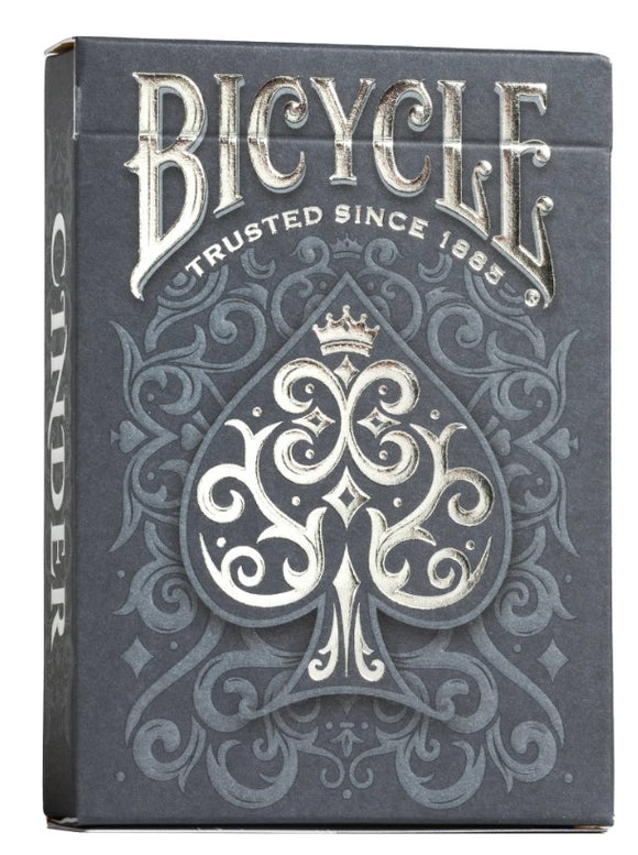Bicycle Cinder card game box featuring an ornate dark gray design with intricate patterns. The prominent spade symbol is elegantly adorned, and the text 'Bicycle' is displayed at the top. The box showcases high-quality craftsmanship characteristic of US Playing Card Co.