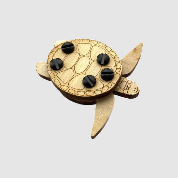 The Loopets Sea Turtle by Zootility is a handcrafted DIY kit featuring a charming wooden sea turtle design. The turtle has a detailed engraved shell with four black buttons for interactive play. Its unique construction allows for fun assembly experiences, making it an engaging craft project for both kids and adults.