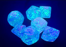 A set of Mini Nebula RPG dice in wisteria and white colors, glowing under black light. The dice feature translucent designs with sparkling glitter and clearly visible numbers on each face, showcasing a captivating blend of colors perfect for tabletop gaming.