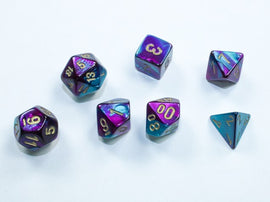A collection of seven Mini Gemini RPG dice in purple, teal, and gold colors, including a D4, D6, D10, D12, D20, and more. The dice feature sharp edges and vibrant color blends, making them perfect for tabletop gaming.