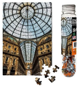 A detailed image of the Italian Galleria Micropuzzle featuring a stunning view of an intricately designed dome and architectural elements. The puzzle pieces are displayed alongside a glass tube containing additional pieces, showcasing the vibrant colors and intricate patterns of the puzzle. Perfect for jigsaw puzzle enthusiasts and architecture lovers.