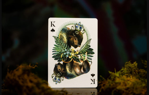A unique playing card featuring the King of Spades design from the Extinct Animals deck by Moooi. The card showcases a beautifully illustrated bison adorned with intricate leafy ferns and floral elements, set against a soft, blurred background. The artistic details highlight the beauty of extinct wildlife in a playful card format.